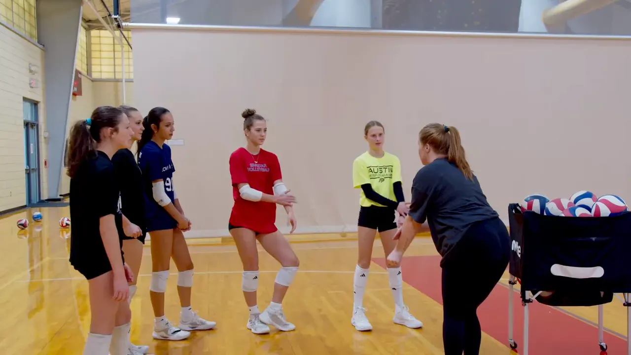 A TVI Trainer coaching a group of young athletes through a drill, then high-fiving them, in a TVI Foundations session