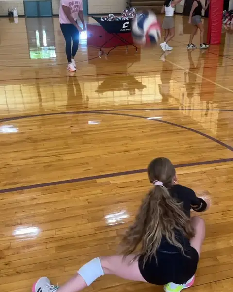 A young libero diving for a dig