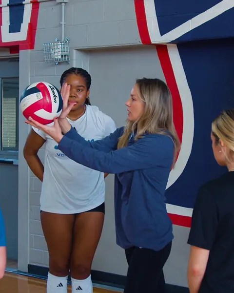 Caitlyn Donahue, a TVI Hub Leader, guiding an athlete’s hand on the ball