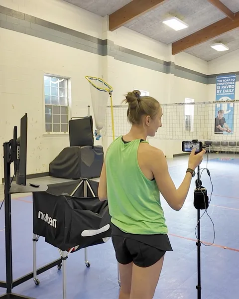 Amanda Peterson, a TVI Trainer, adjusting a phone camera on a stand beside a screen, with a setter target behind her