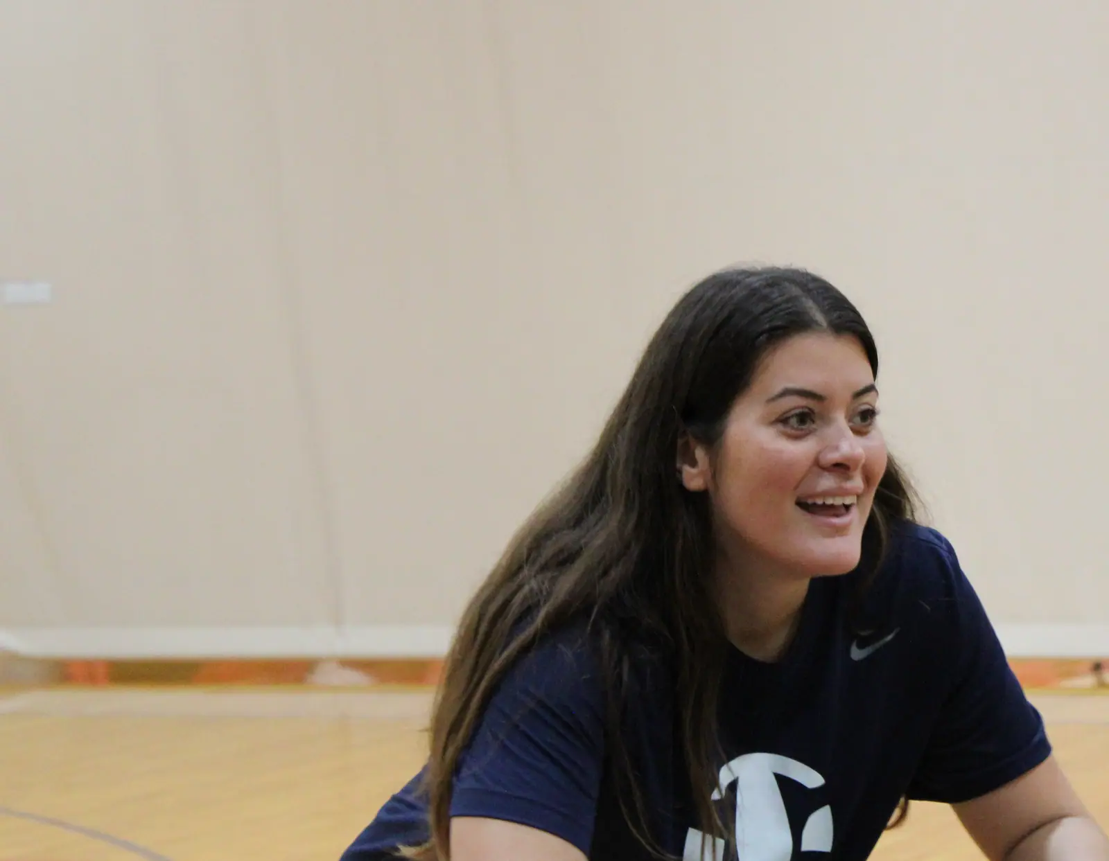 Paulina Prieto Cerame, a TVI Trainer, laughing as she kneels to talk an athlete through a drill